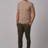Modelo vestindo calça cor verde masculina de sarja com corte reto