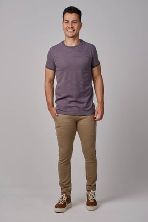 Modelo vestindo calça cor caqui masculina de sarja com corte reto