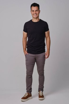 Modelo vestindo calça cor cinza masculina de sarja com corte reto